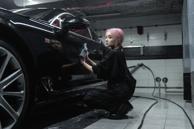 A towel wiping water from black paint